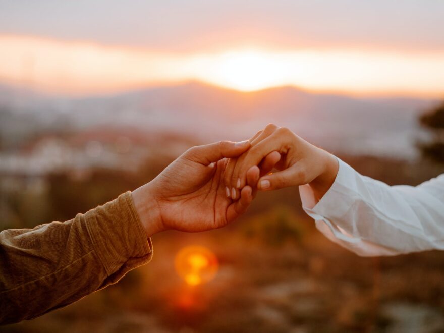 To be trusted is a great compliment header shows unrecognizable couple holding hands at sunset
