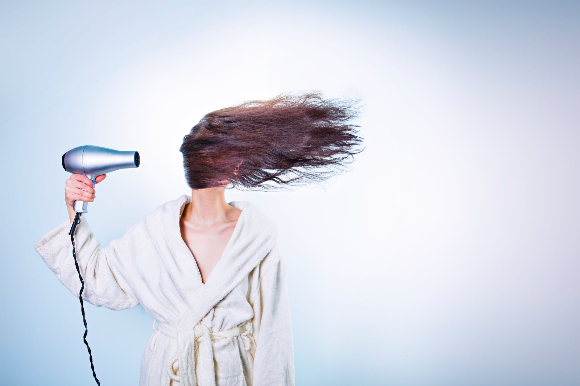 Don't get stuck in a rut header image shows person in a bathrobe, with a hair dryer blowing hair across their face.