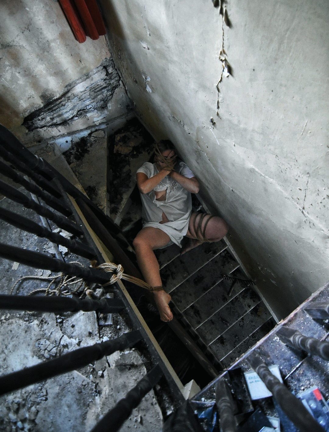BDSM is a game header shows lady in a torn white cotton nightdress, bound on crumbing stairs.