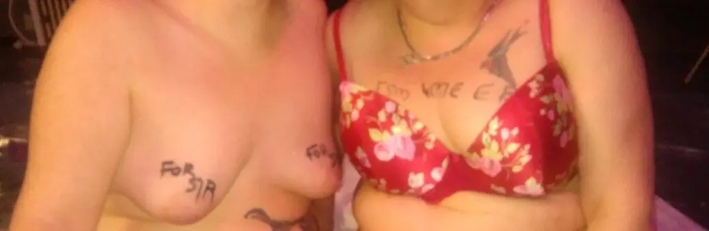 CC and I all ready for the bukkake party. Picture of our chests as we sit next to each other before we got started. my breasts with For sir writing on them, hers with HSM, FSM, EB and me written on there. 