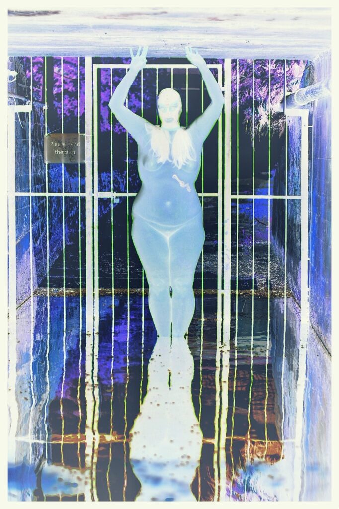 A negative spin on things header image shohws naked lady standing in a flooded tunnel, reflected in the water, with a filter added for a negative effect.