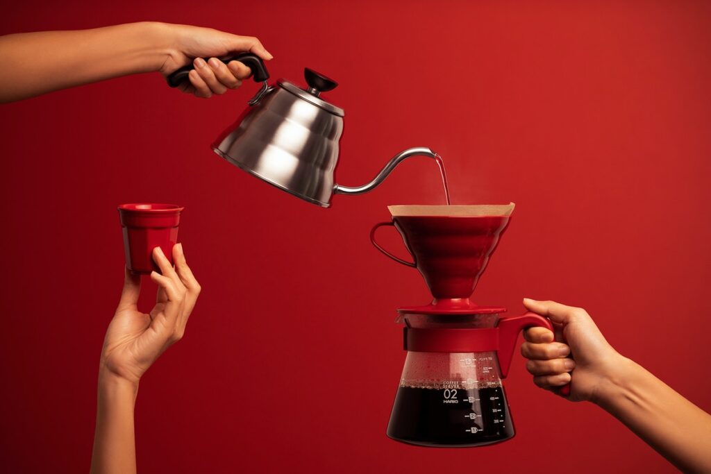 Personal review of 2021 header image shows hand holding kettle pouring water into a coffee maker held by a second hand. While a third hand holds up a cup.