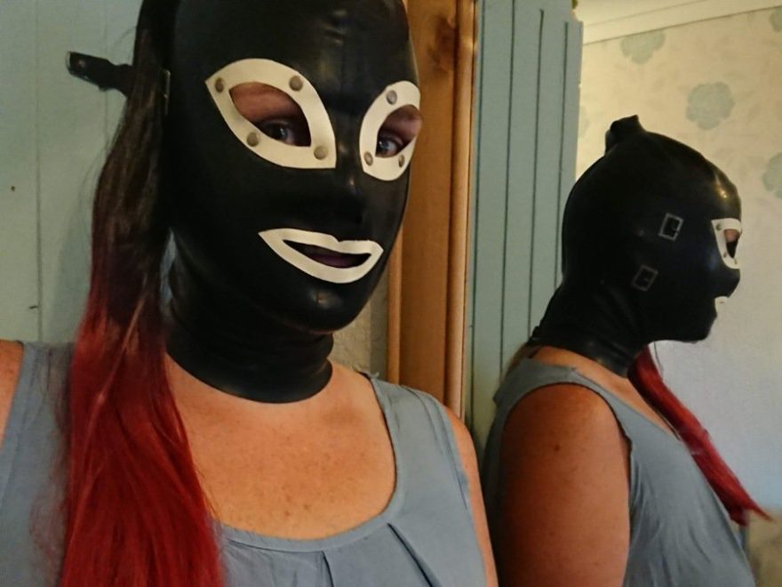encased in latex enclosure hood with a pony tail