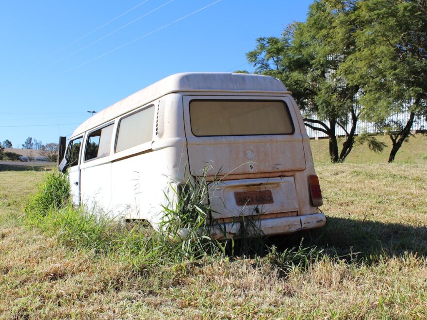 Self-destuction and turmoil header image shows abandoned camper van in an empty field.