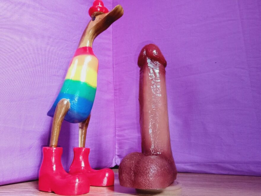 Bestvibe Cupid suction cupped to the floor next to a rainbow painted wooden duck.