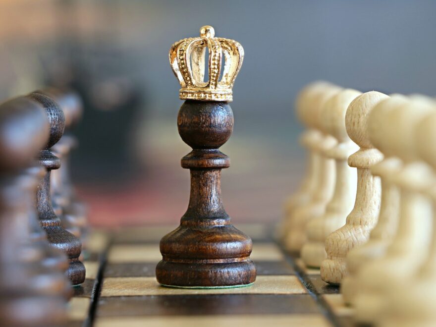 A chess piece pawn has become a queen by adding a gold crown on top.