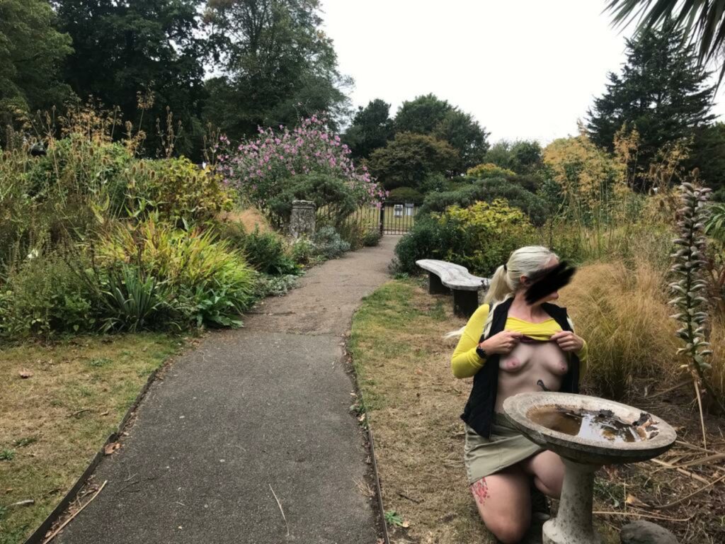Barefoot by a birdbath in a Plymouth park with her boobs out.