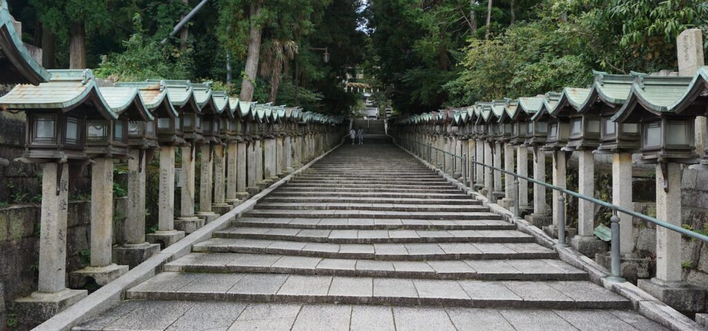 lots of little steps leading up to a temple hiding between the trees.